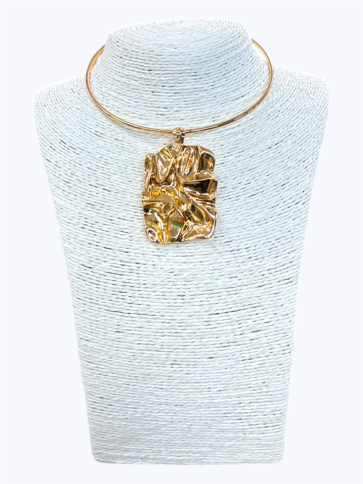 Gold-tone abstract textured pendant choker necklace with minimalist open collar design displayed on woven jewelry bust for modern statement boutique fashion accessories collection