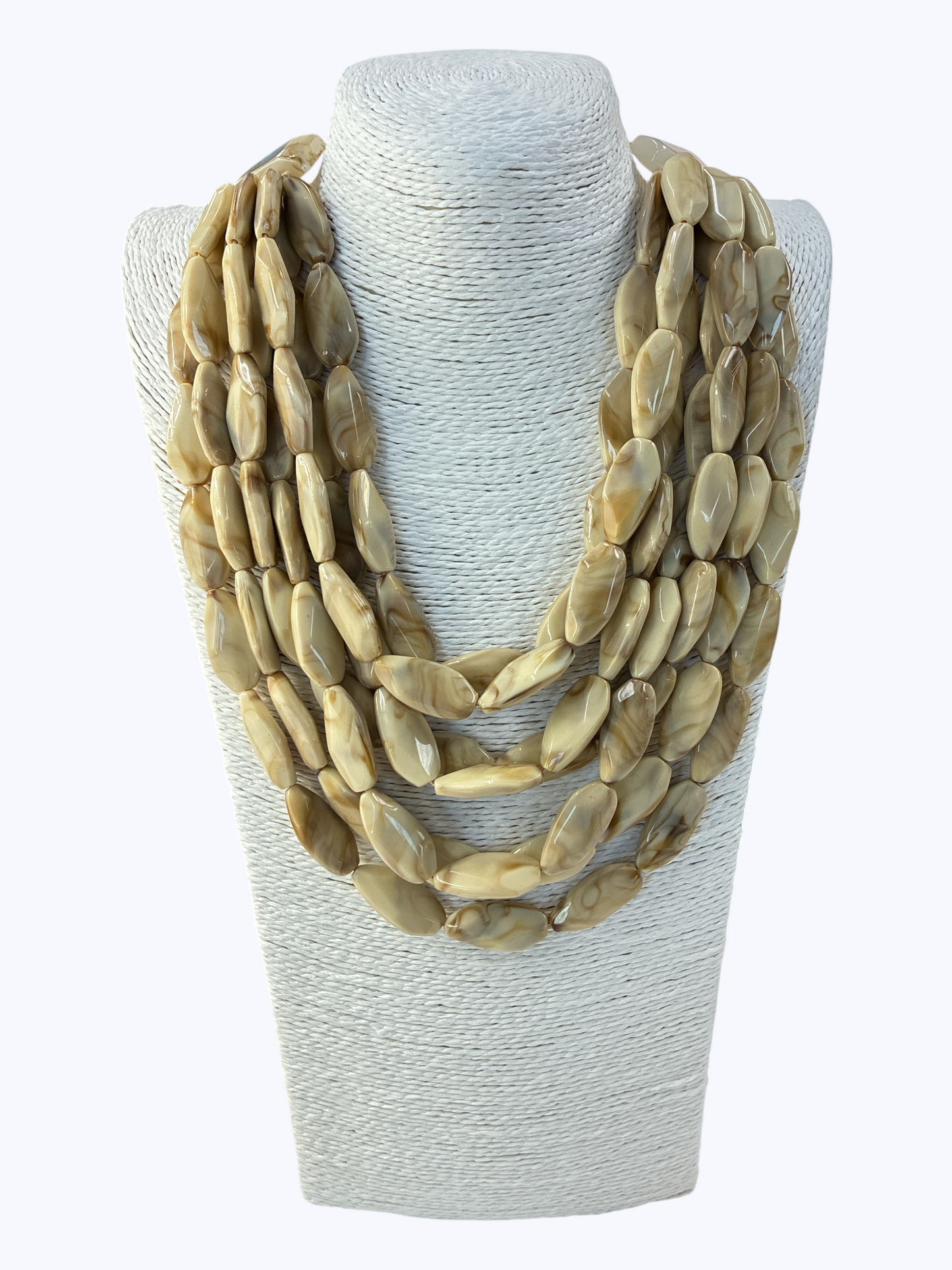 Beige stone necklace on a white mannequin bust