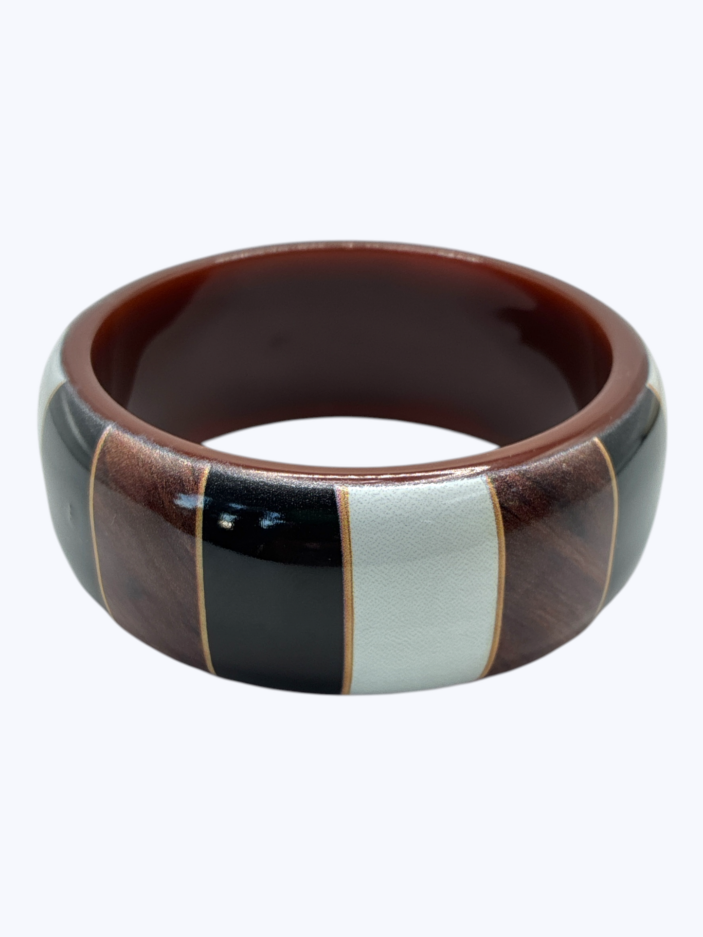 Ceramic bowl with brown, black, and white stripes on a white background