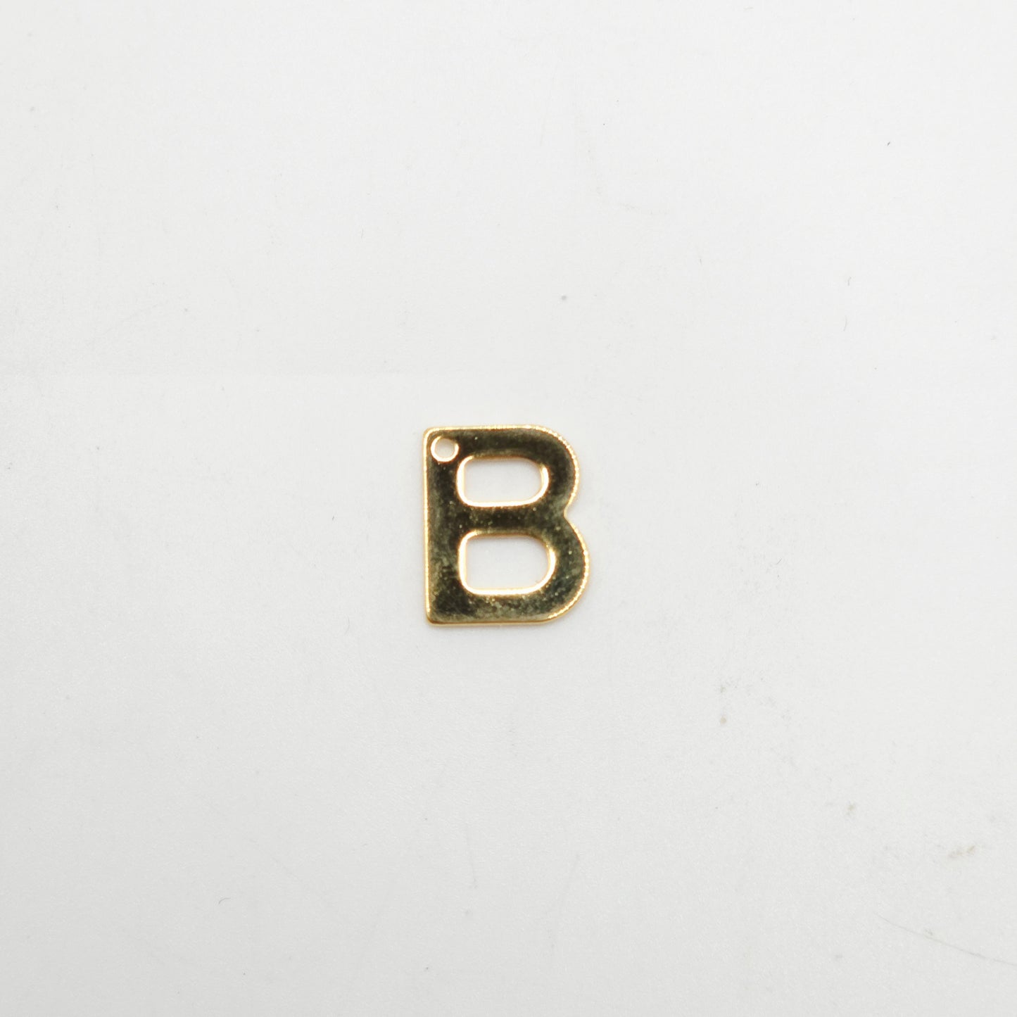 Gold letter 'B' charm on a white background