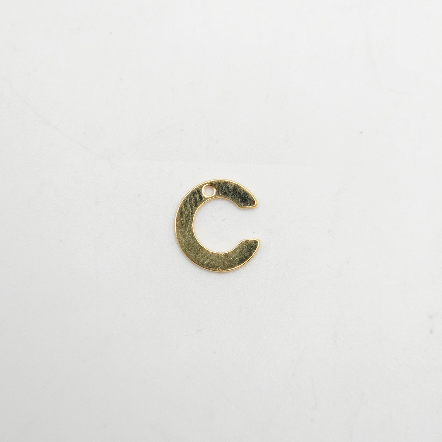 Gold letter 'C' charm on a white background