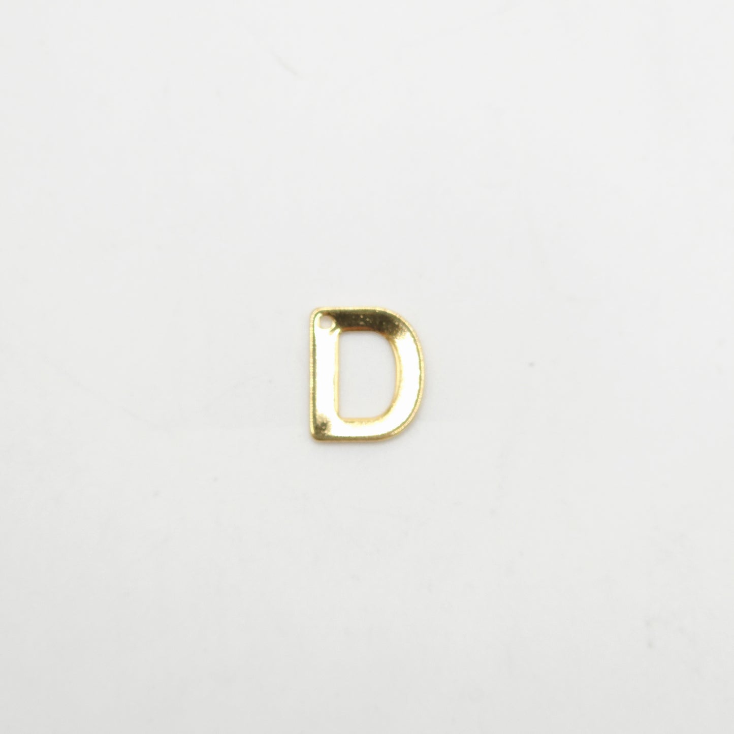 Gold letter 'D' charm on a white background
