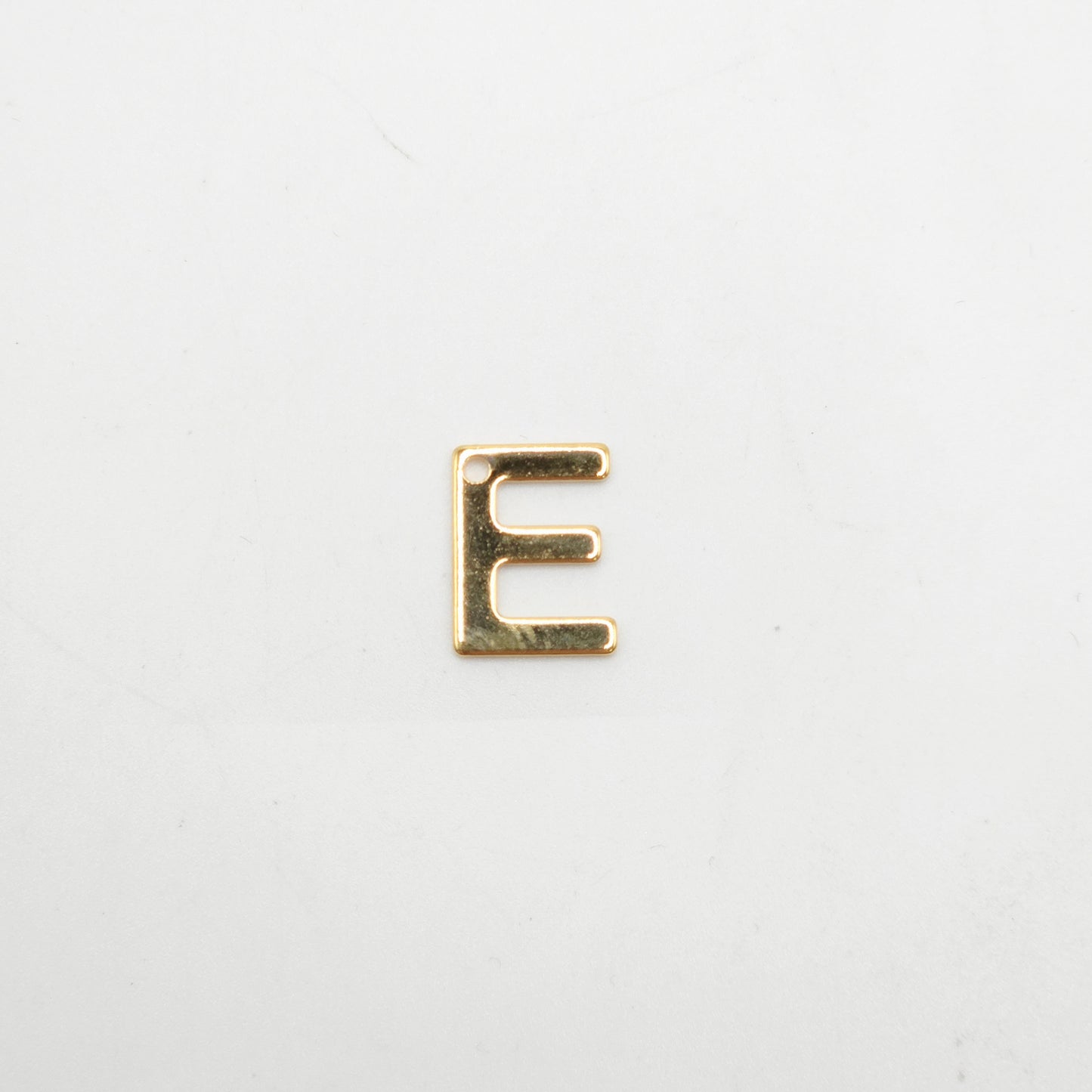 Gold letter 'E' charm on a white background