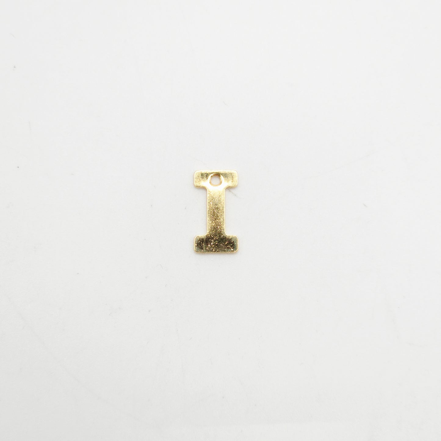 Gold letter 'I' charm on a white background