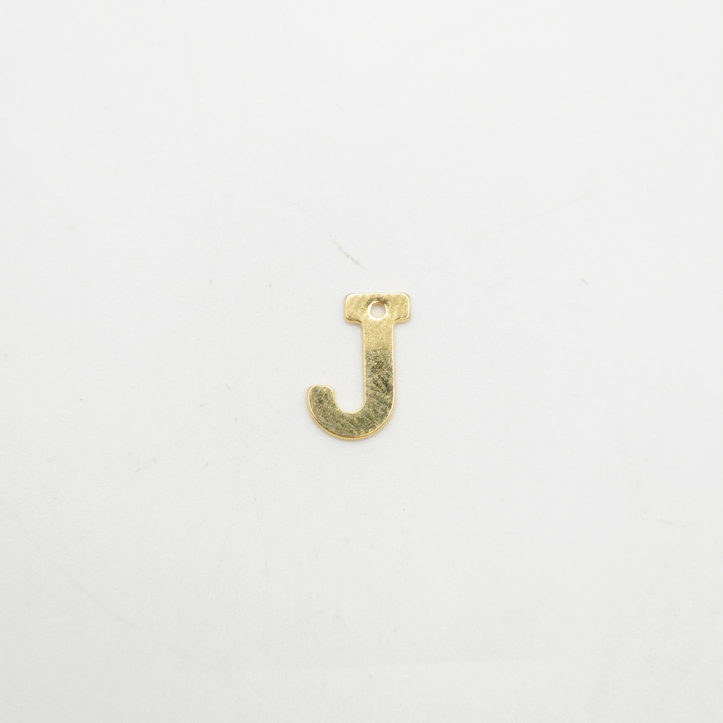 Gold letter 'J' charm on a white background