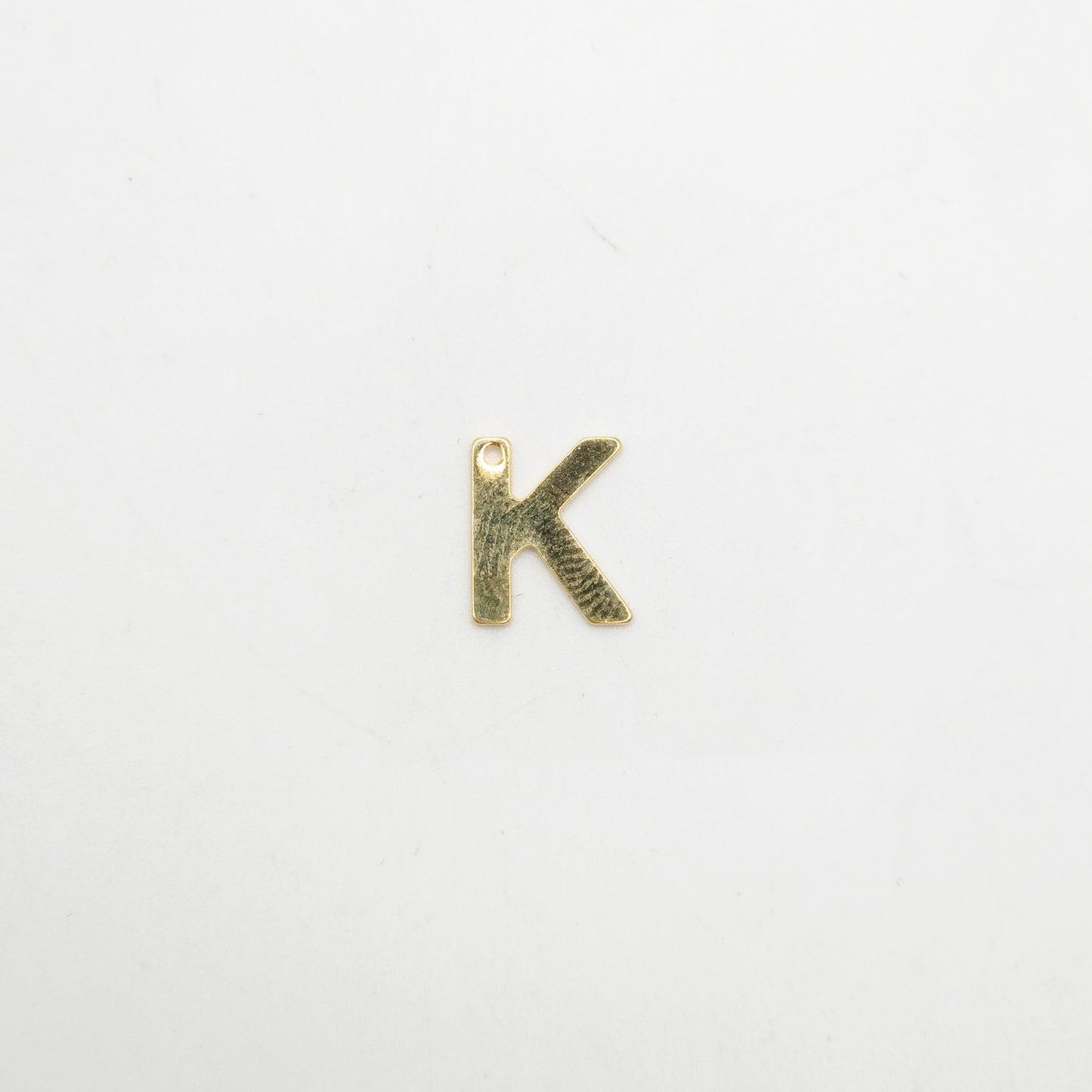 Bronze letter 'K' pendant on a white background