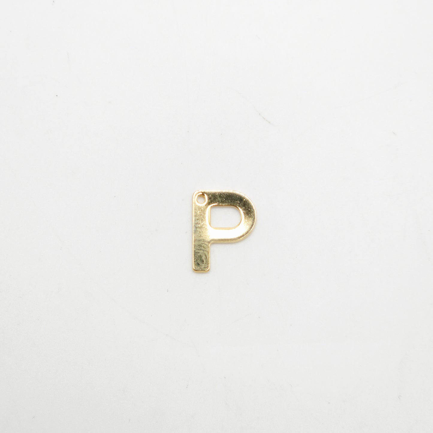 Gold letter 'P' charm on a white background