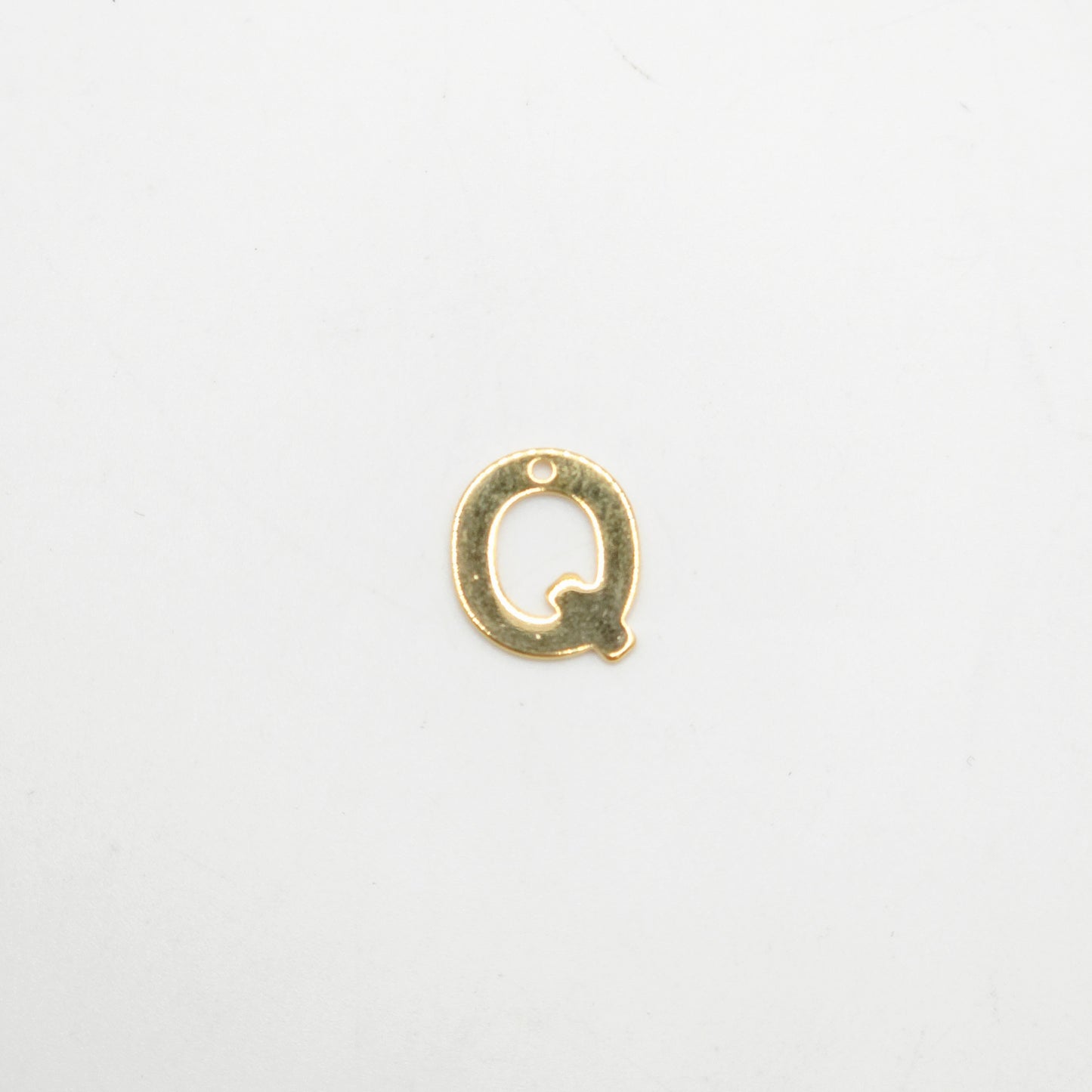Gold letter 'Q' charm on a white background