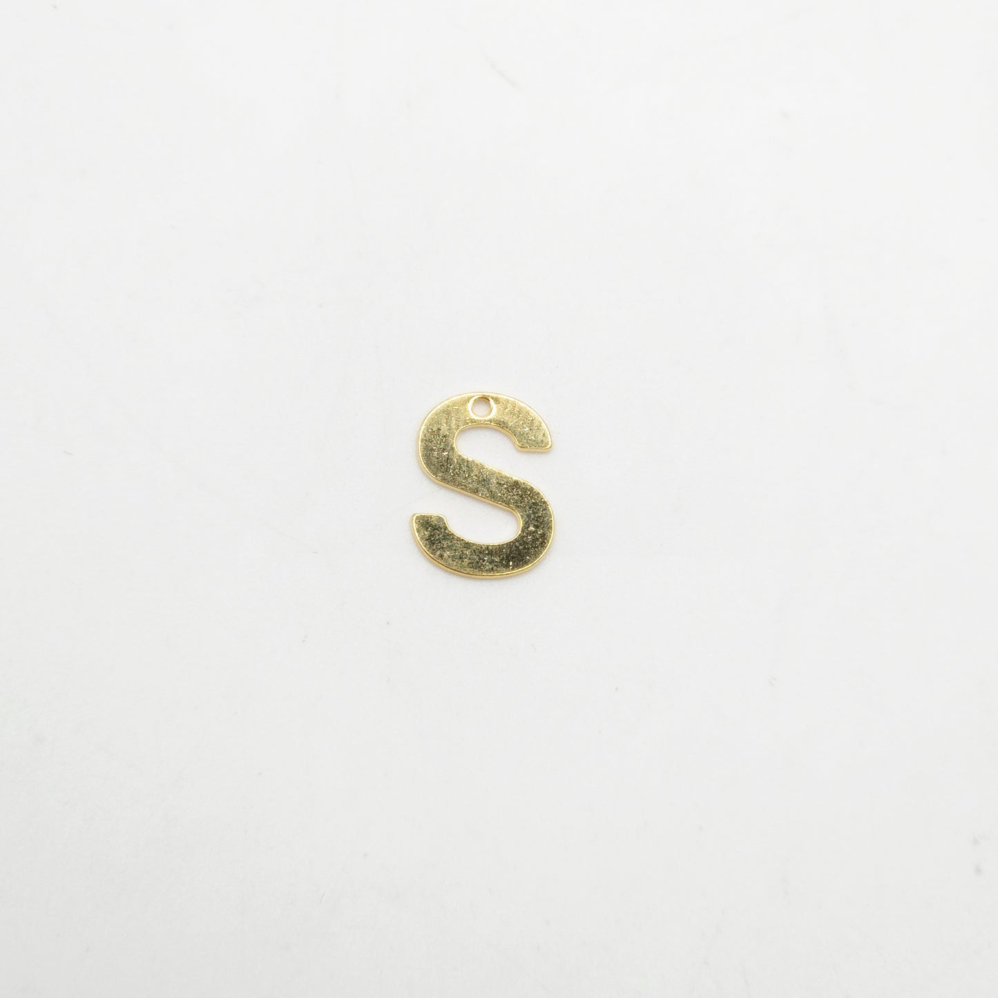 Gold letter 'S' charm on a white background