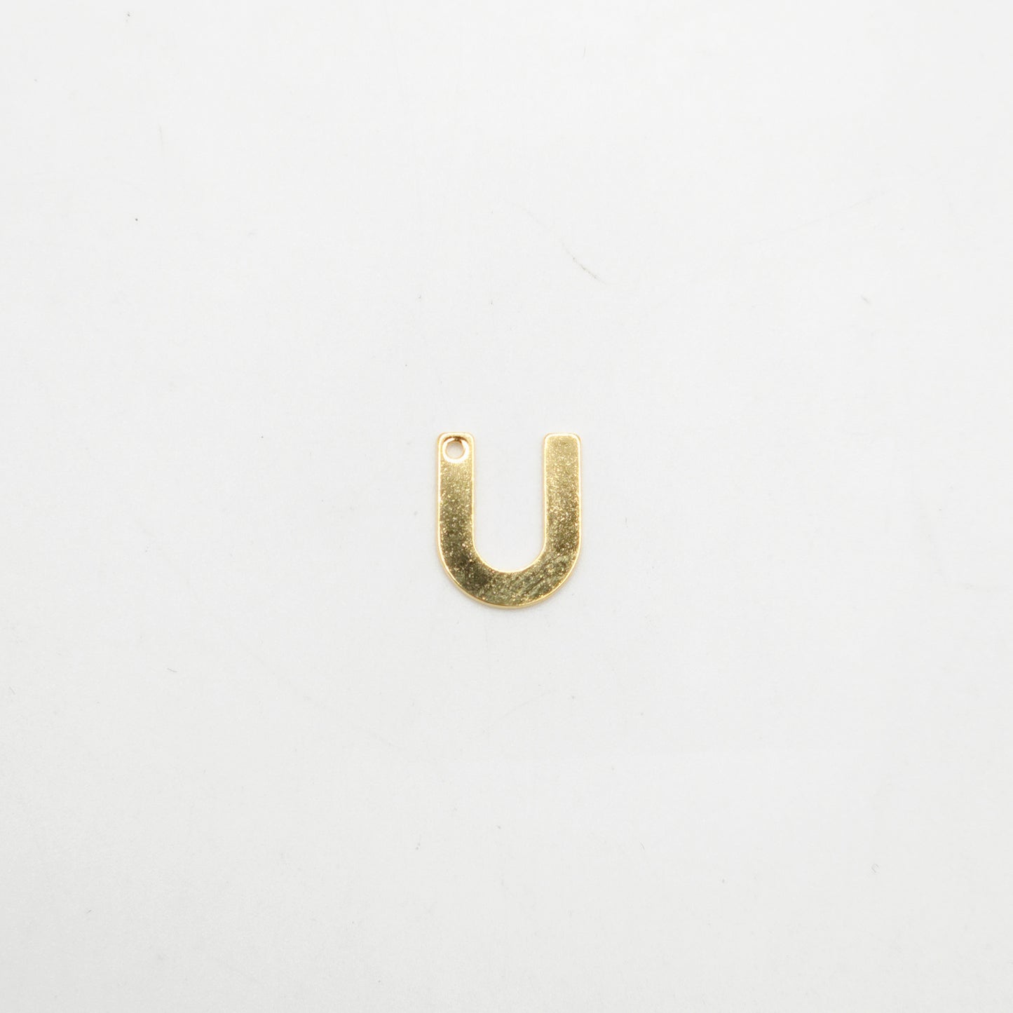Gold U-shaped pendant on a white background