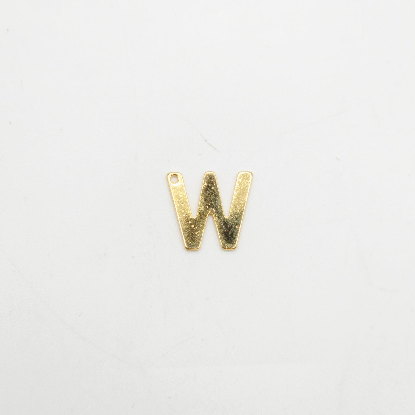 Gold letter 'W' charm on a white background