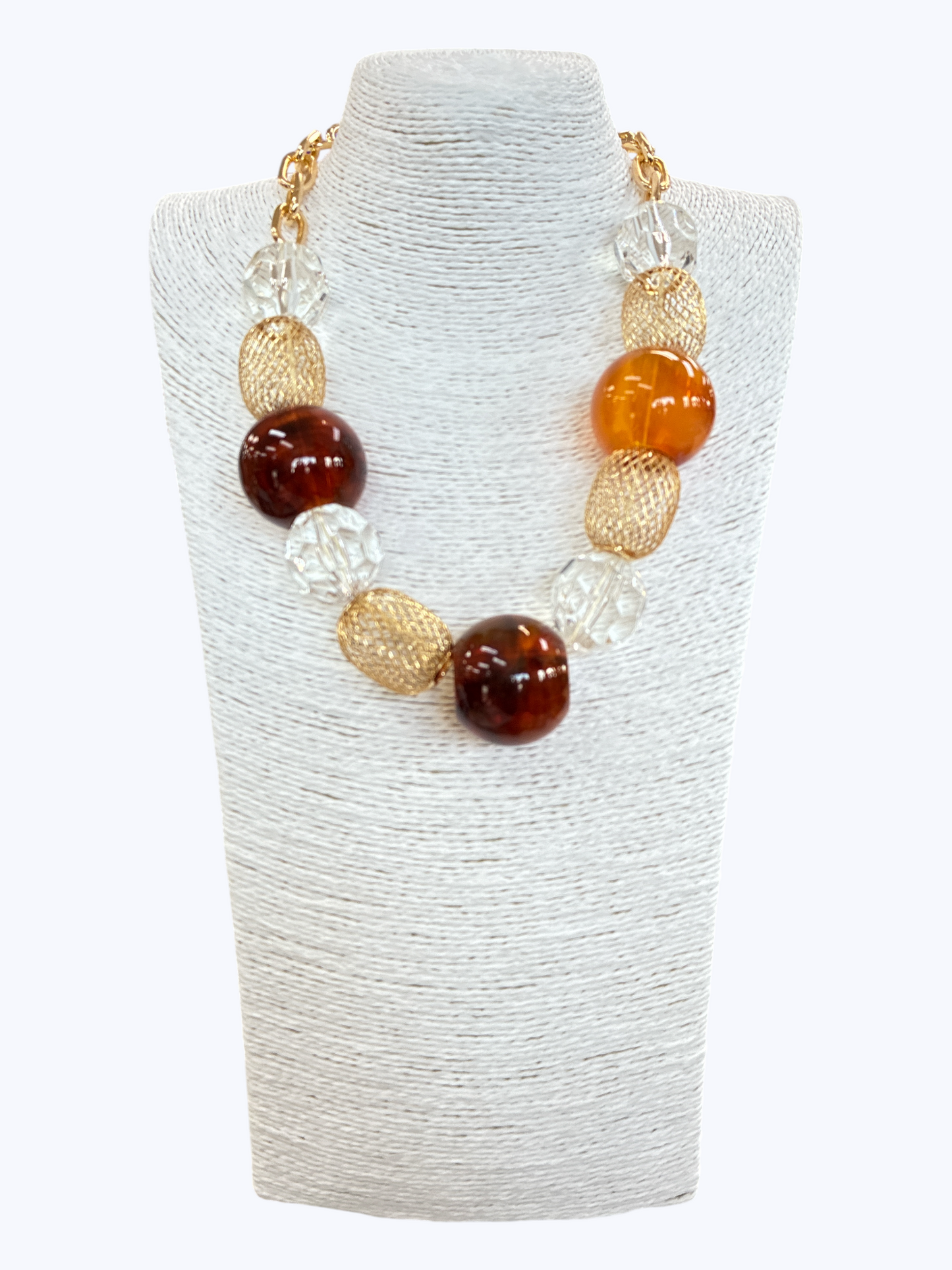 Chunky boutique necklace featuring oversized amber-inspired acrylic beads, textured metallic oval links, and clear faceted beads on gold chain.