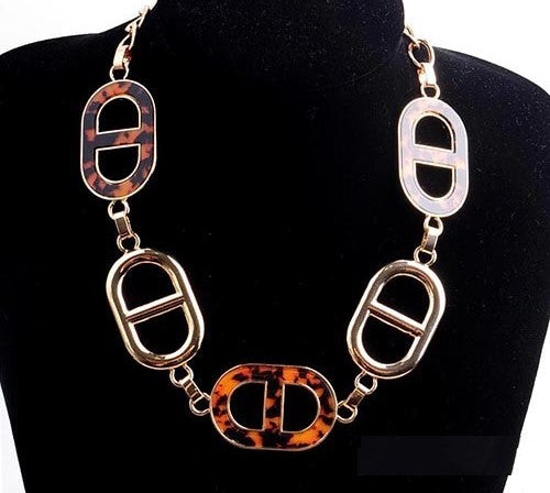 Necklace with tortoiseshell and silver links on a black stand