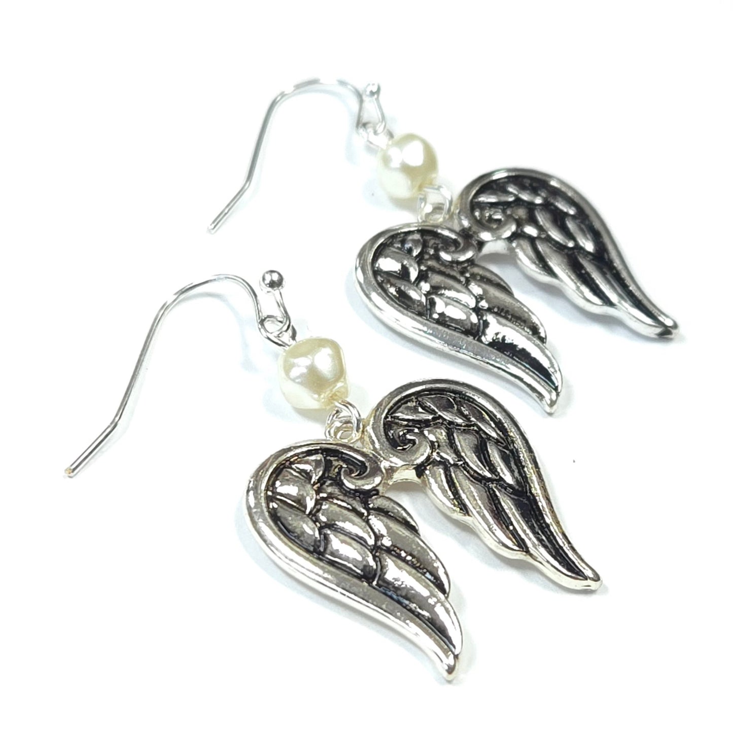 Silver angel wing earrings with pearl accents on a white background