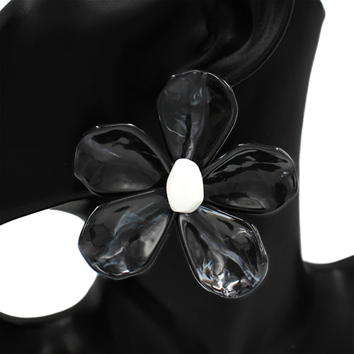 Black flower-shaped ring with a white center on a black background