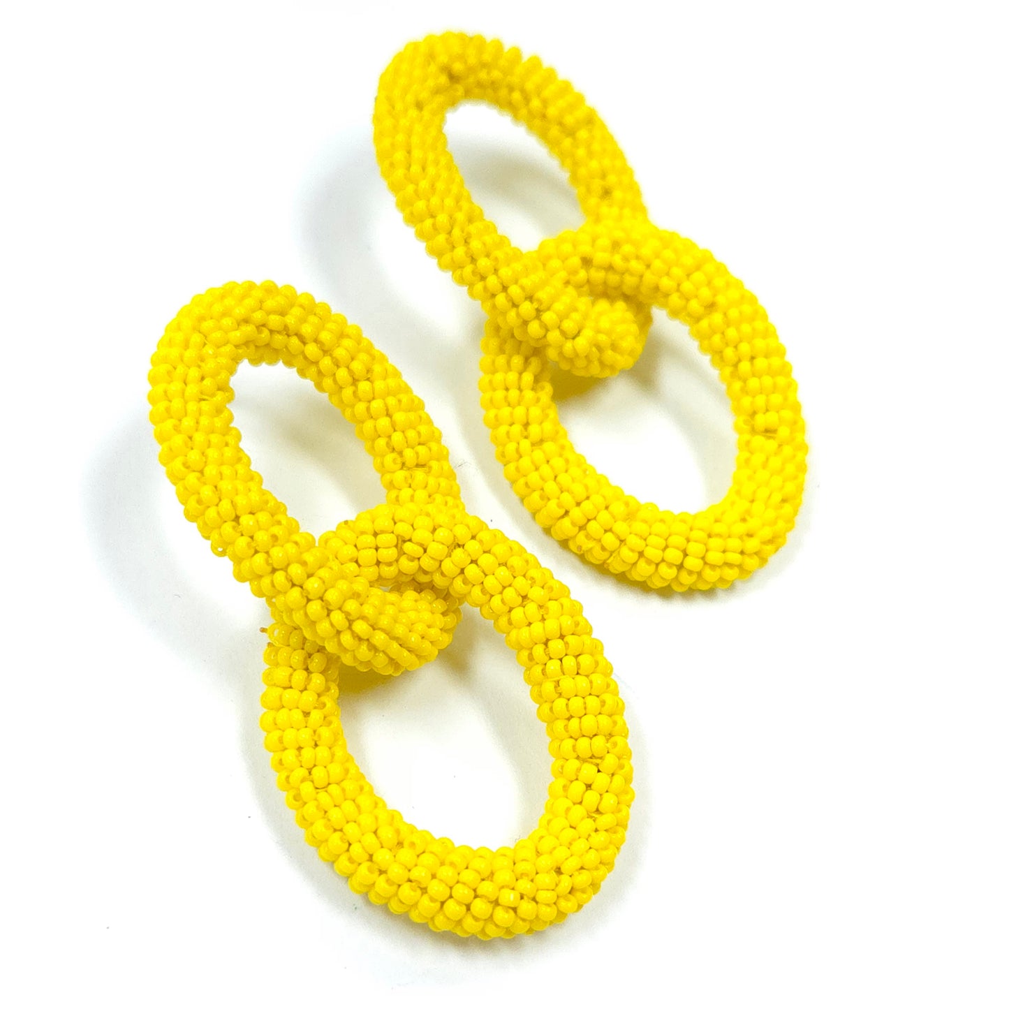 Pair of yellow earrings on a white background