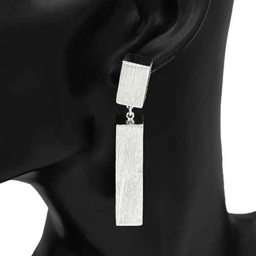 Silver bar earrings on a black mannequin ear against a white background