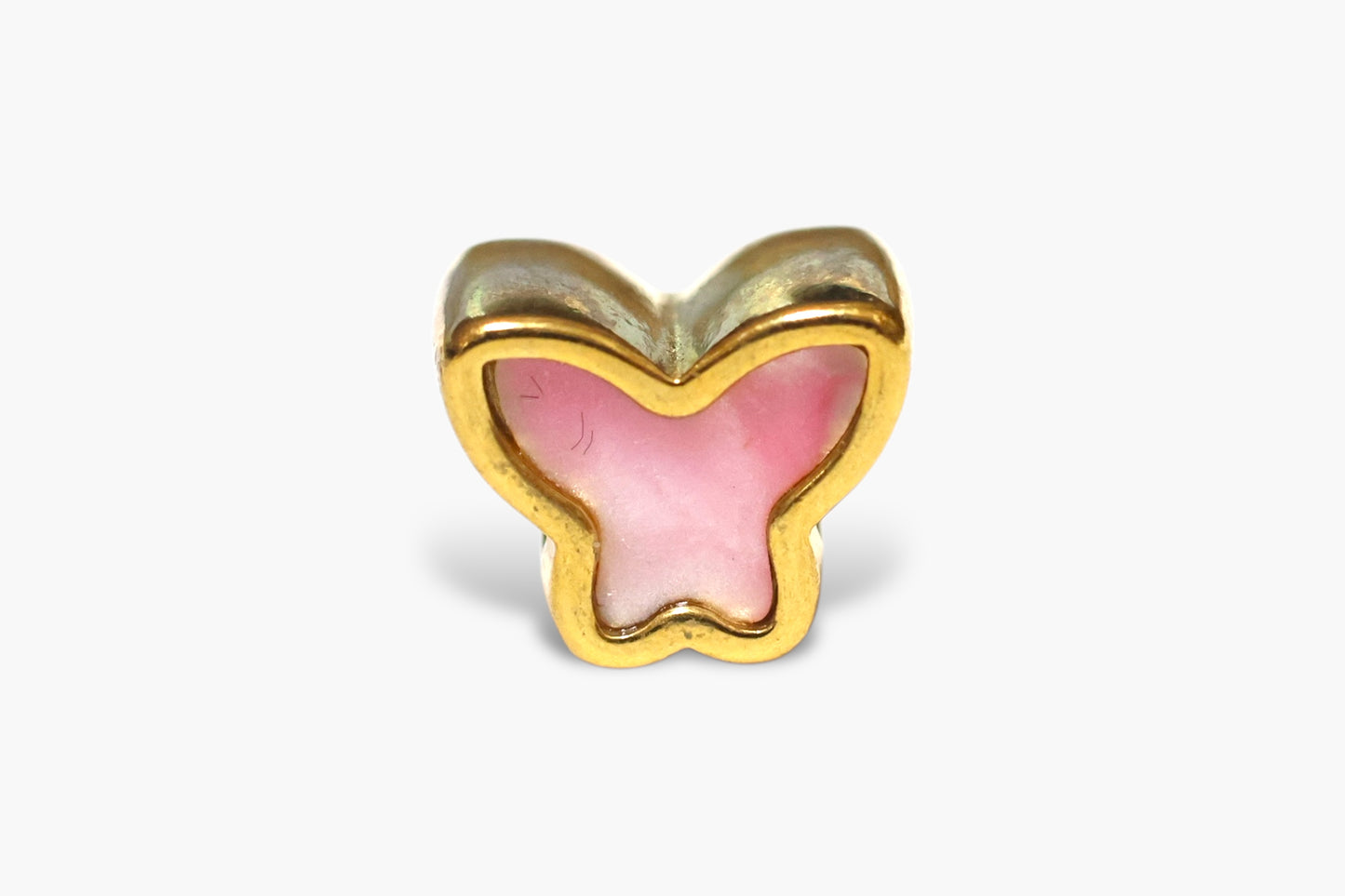 Butterfly-shaped object with pink center and gold border on a white background