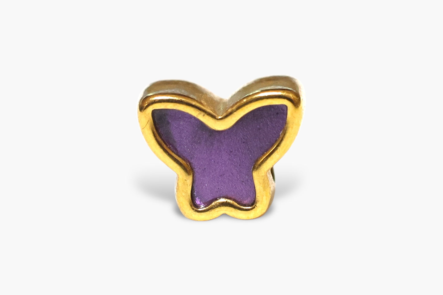 Butterfly-shaped object with purple center and gold border on a white background