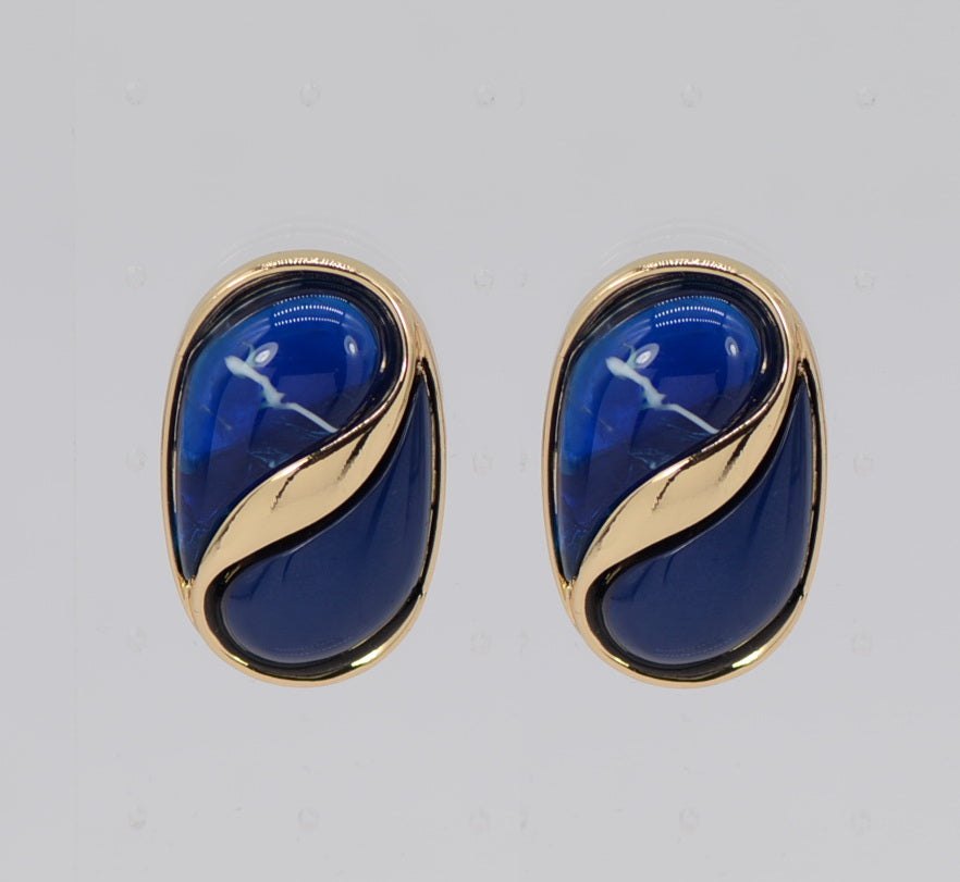 Pair of blue earrings with gold accents on a light gray background