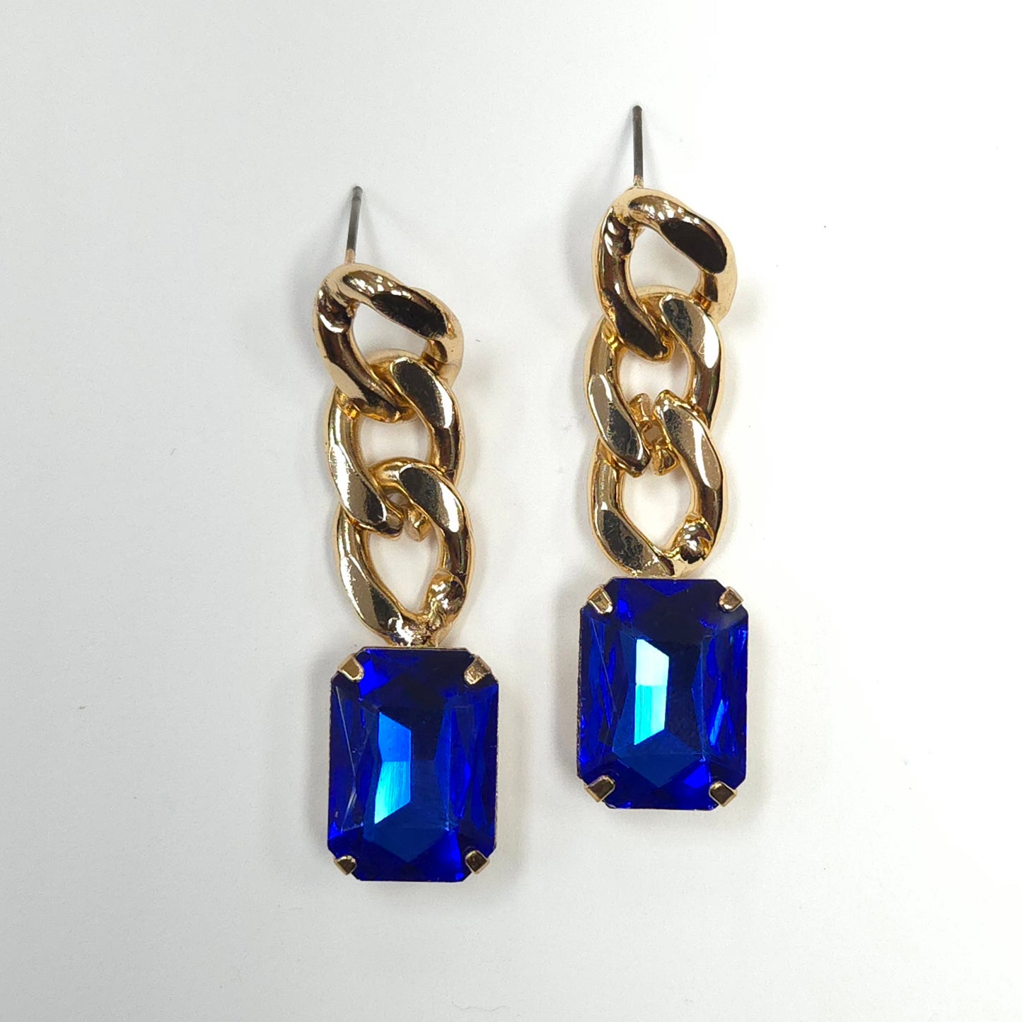 Gold chain earrings with blue gemstones on a white background