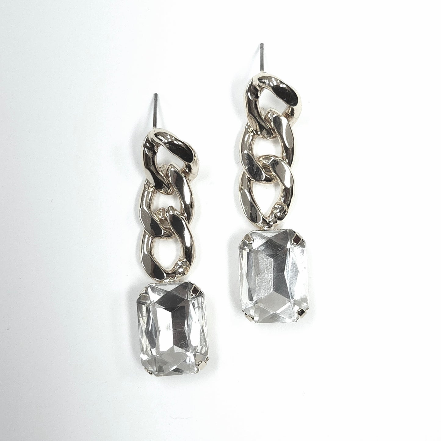 Silver chain earrings with clear gemstones on a white background
