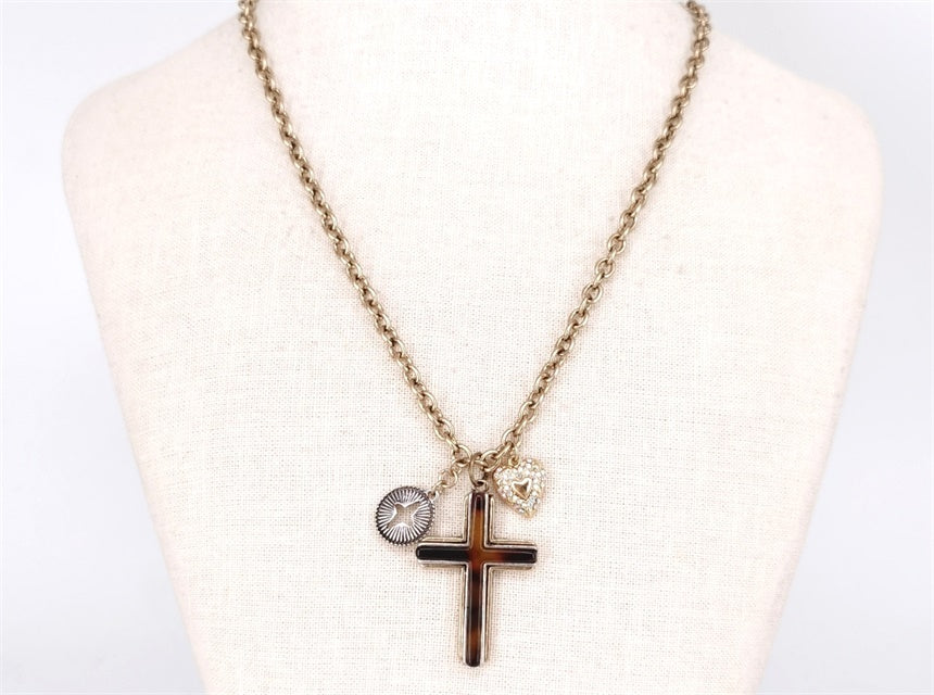 Necklace with cross pendant and round charm on a mannequin bust.