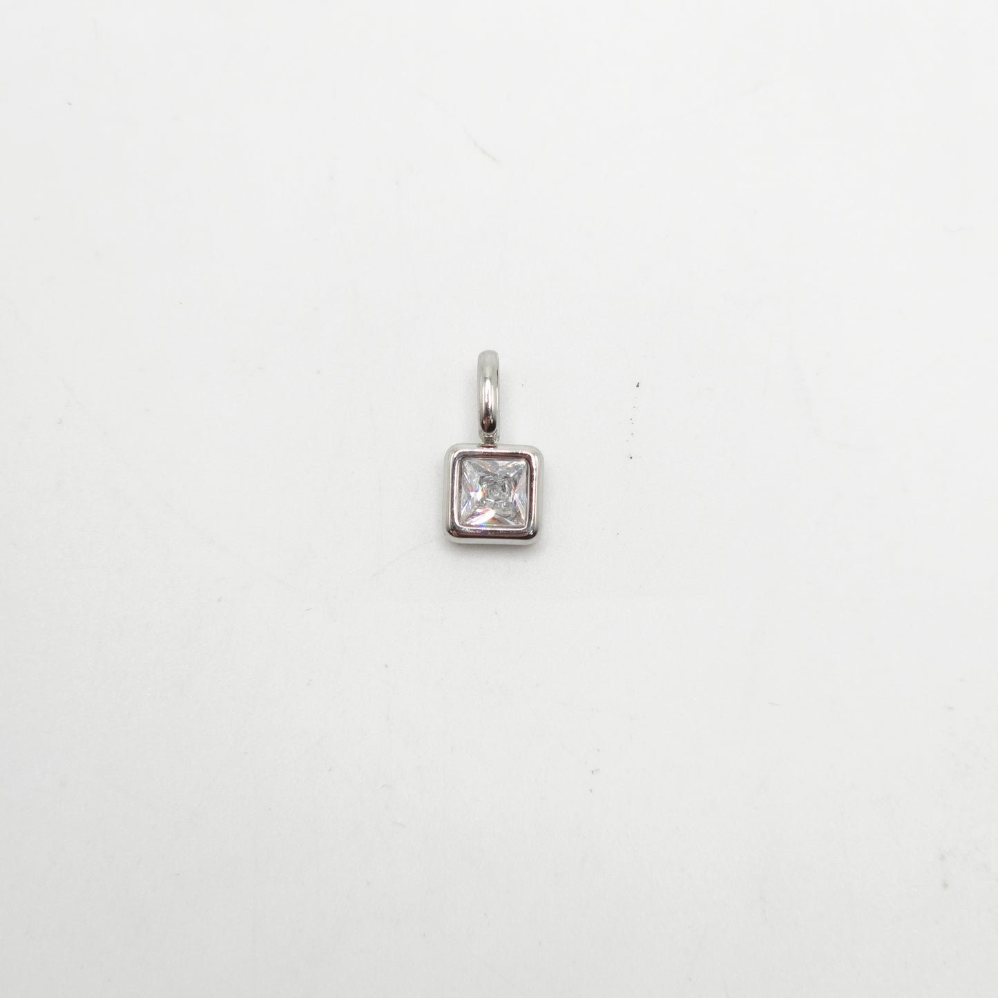 Silver pendant with a square-cut gemstone on a white background