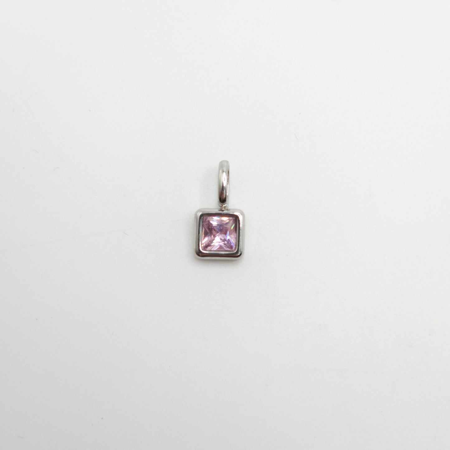Silver pendant with a pink gemstone on a white background
