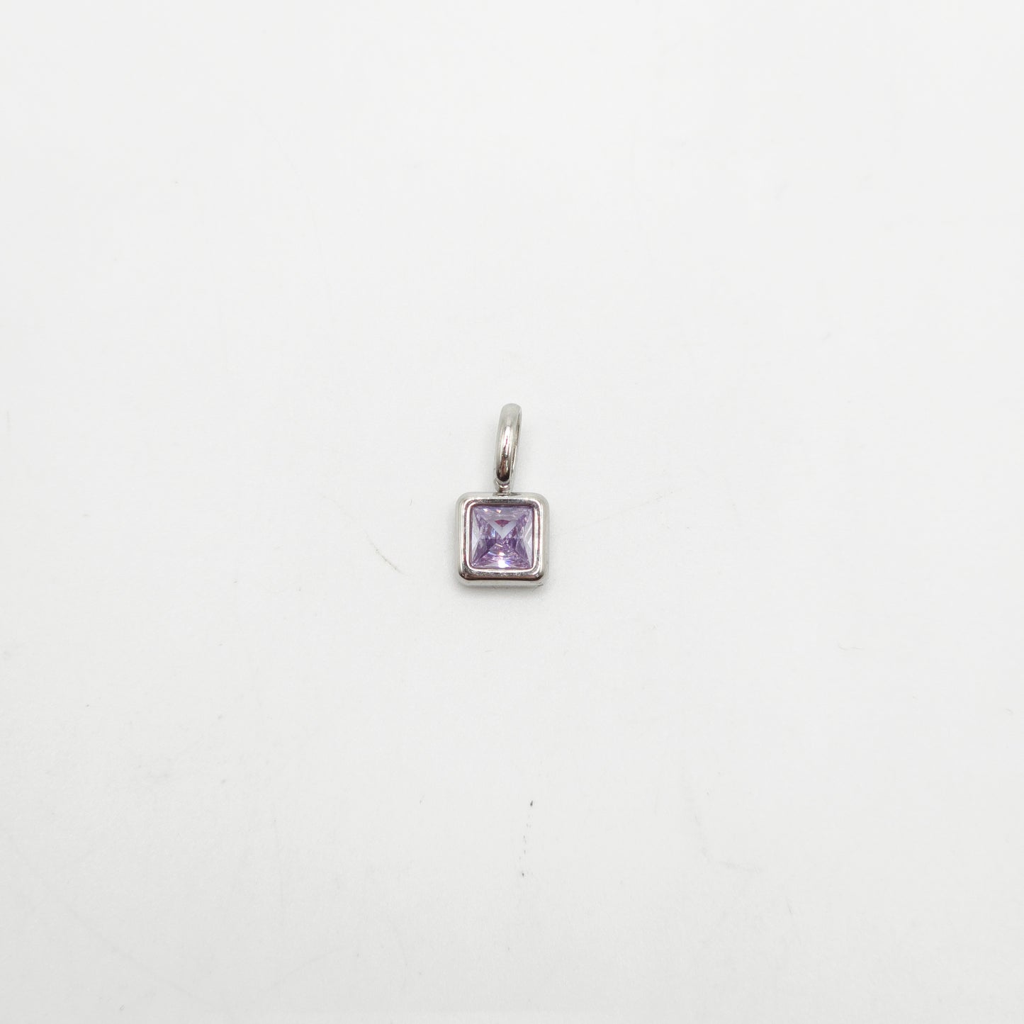 Silver pendant with a purple gemstone on a white background
