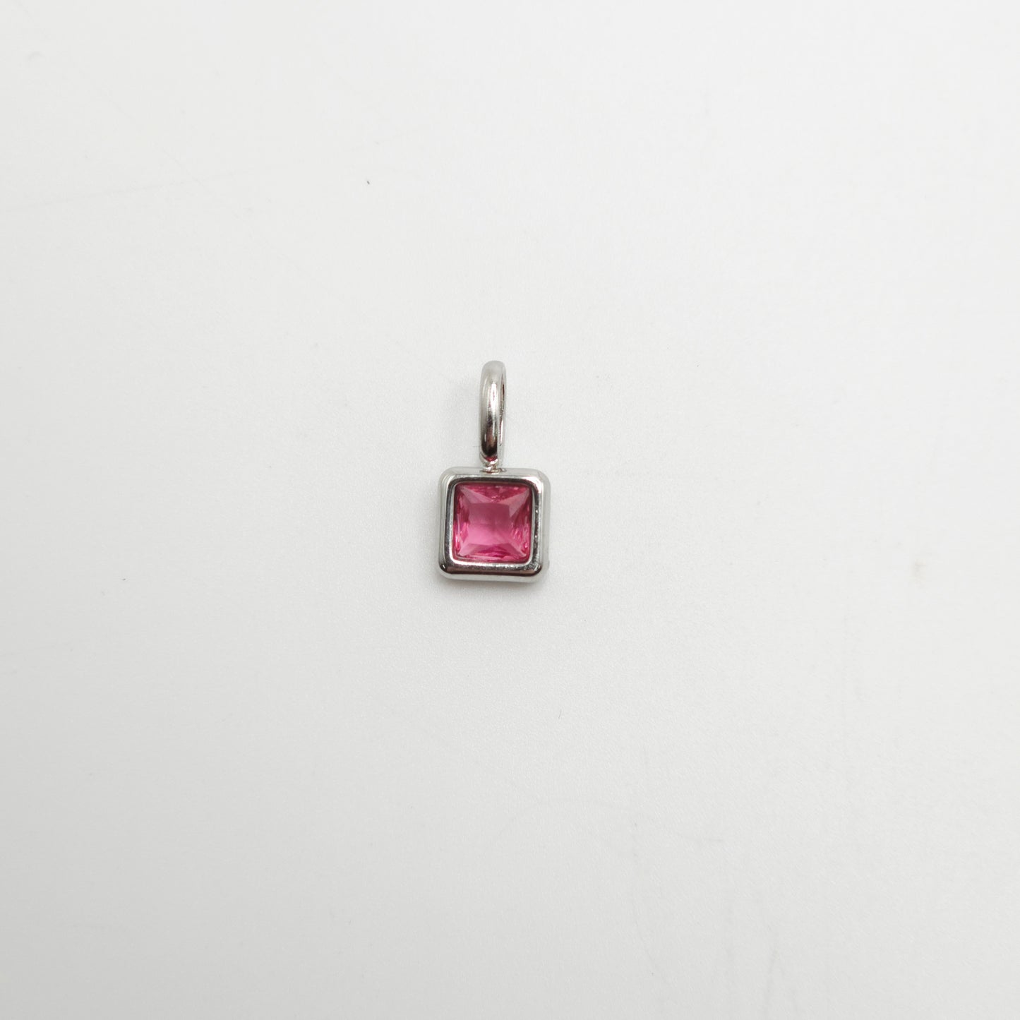Silver pendant with a pink gemstone on a white background