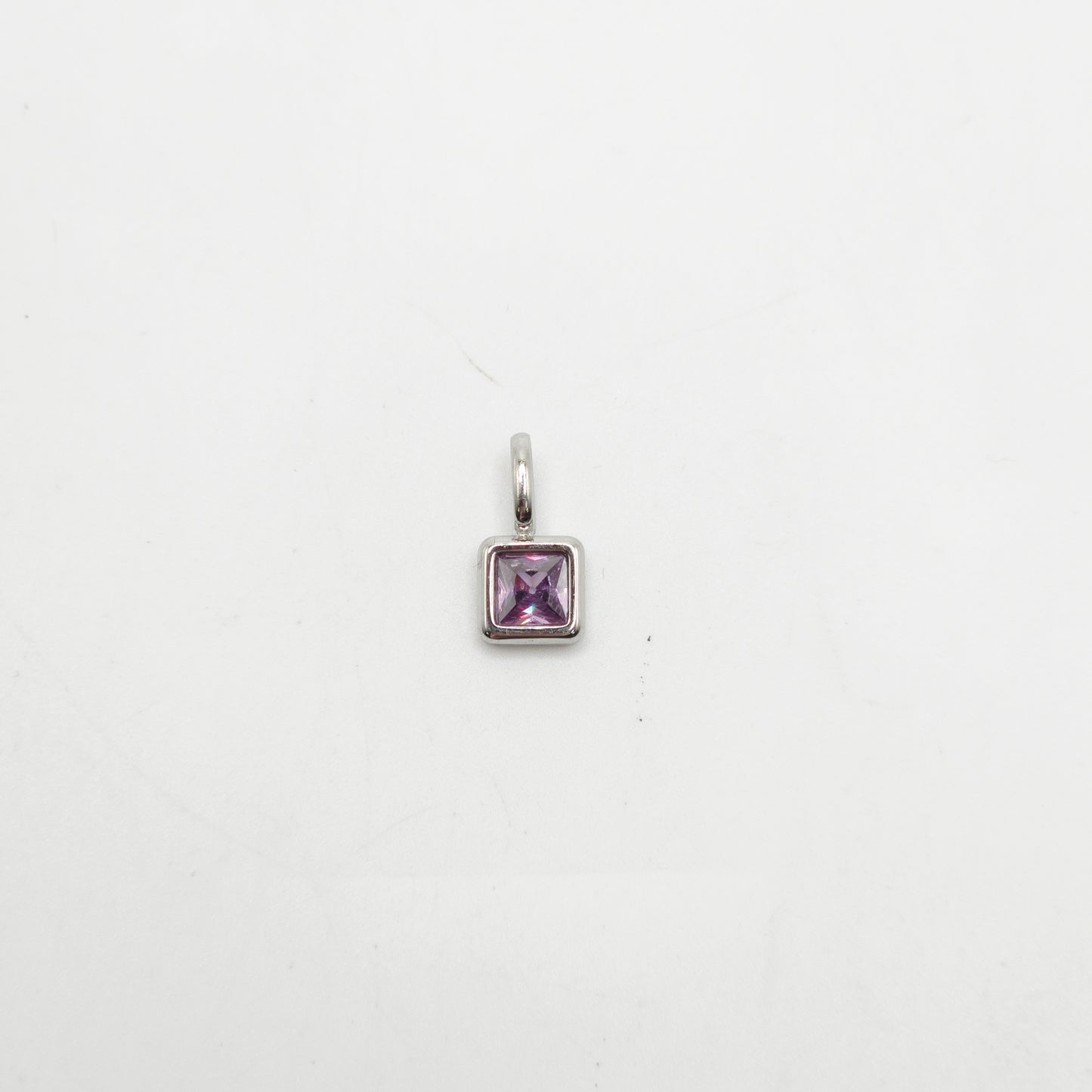 Silver pendant with a purple gemstone on a white background