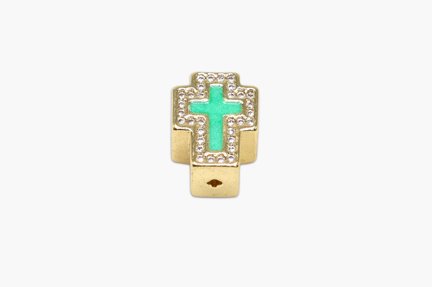 Gold cross-shaped earring with a green gemstone on a white background