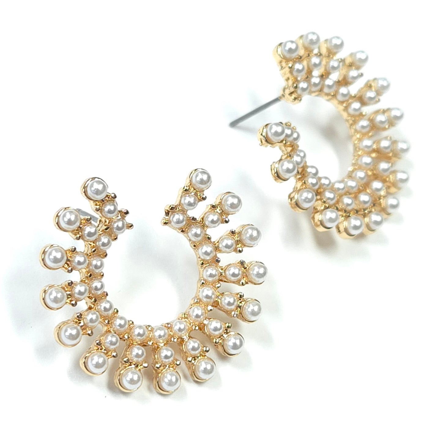 Gold and pearl earrings on a white background