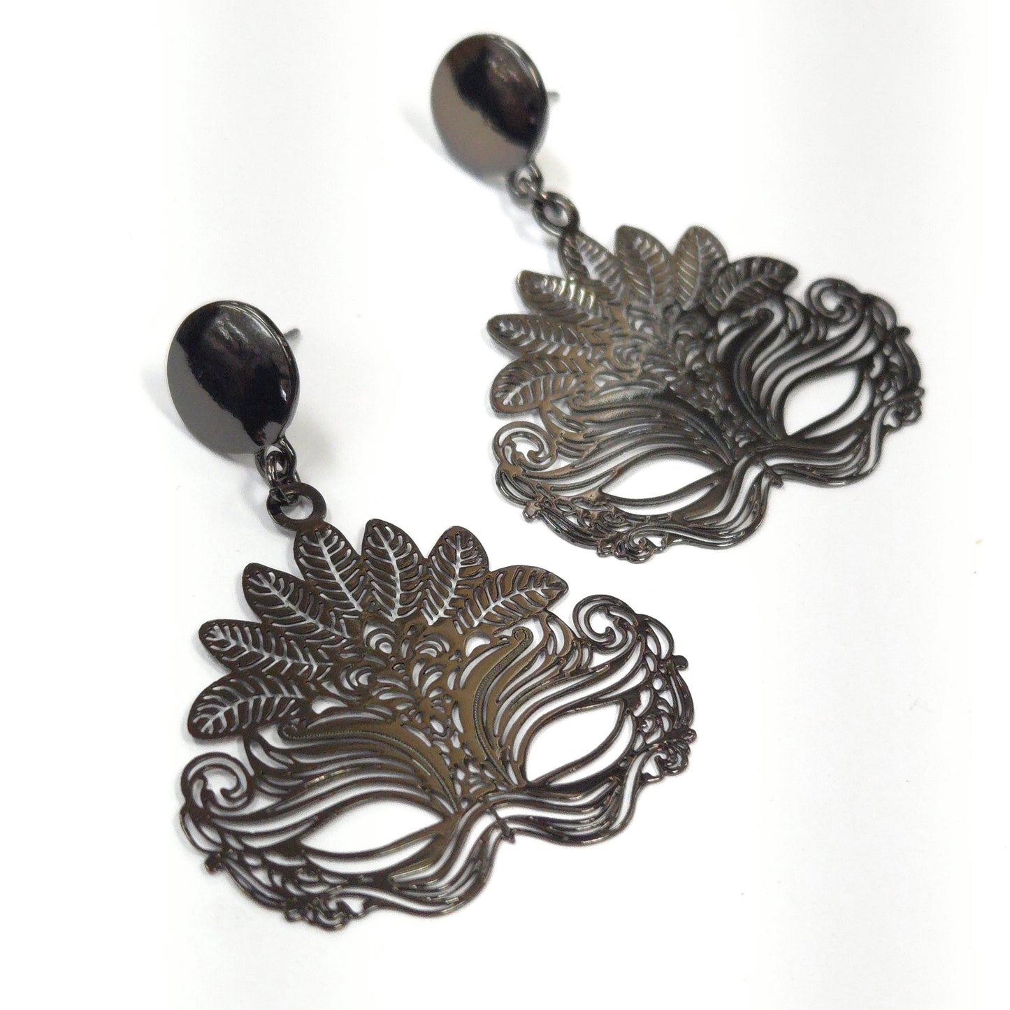Pair of ornate mask-shaped earrings on a white background