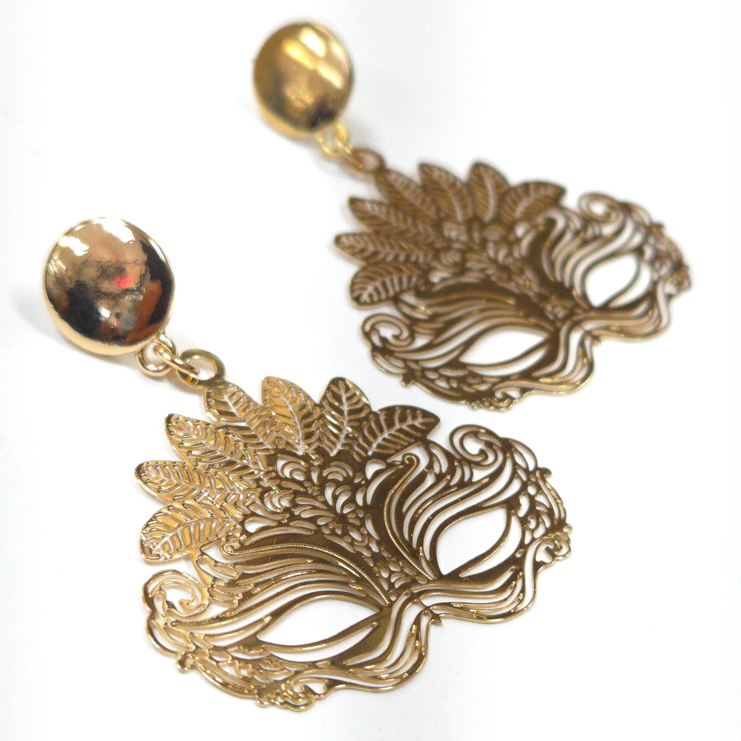 Pair of gold earrings with intricate designs on a white background