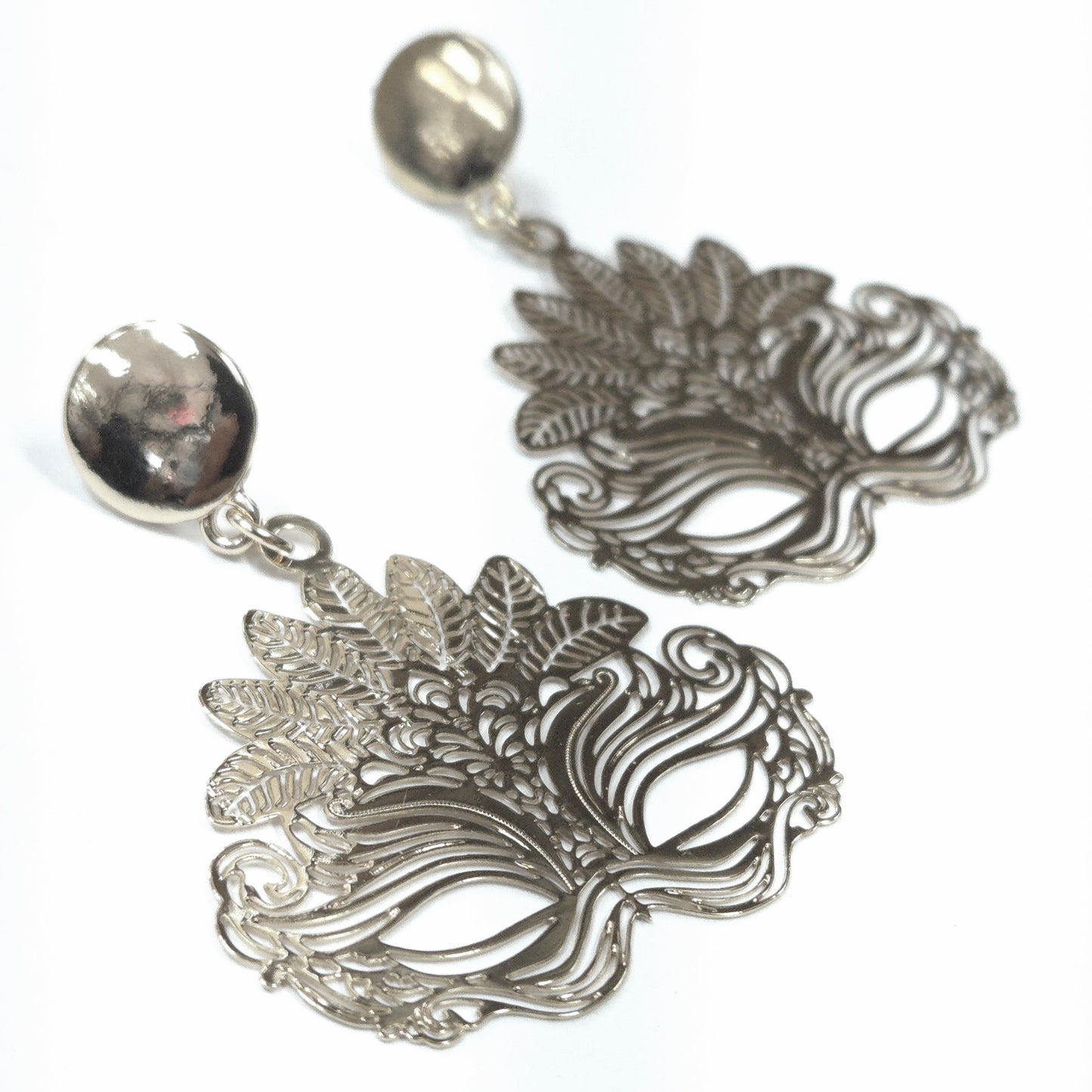 Pair of silver earrings with intricate designs on a white background