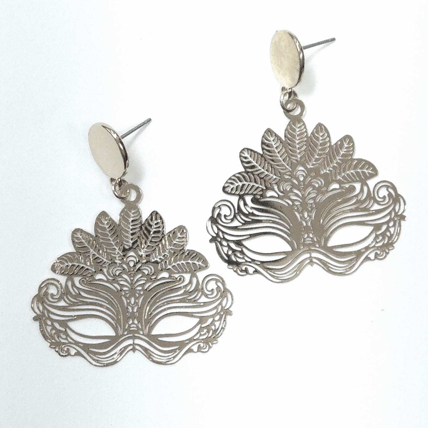 Silver mask-shaped earrings on a white background