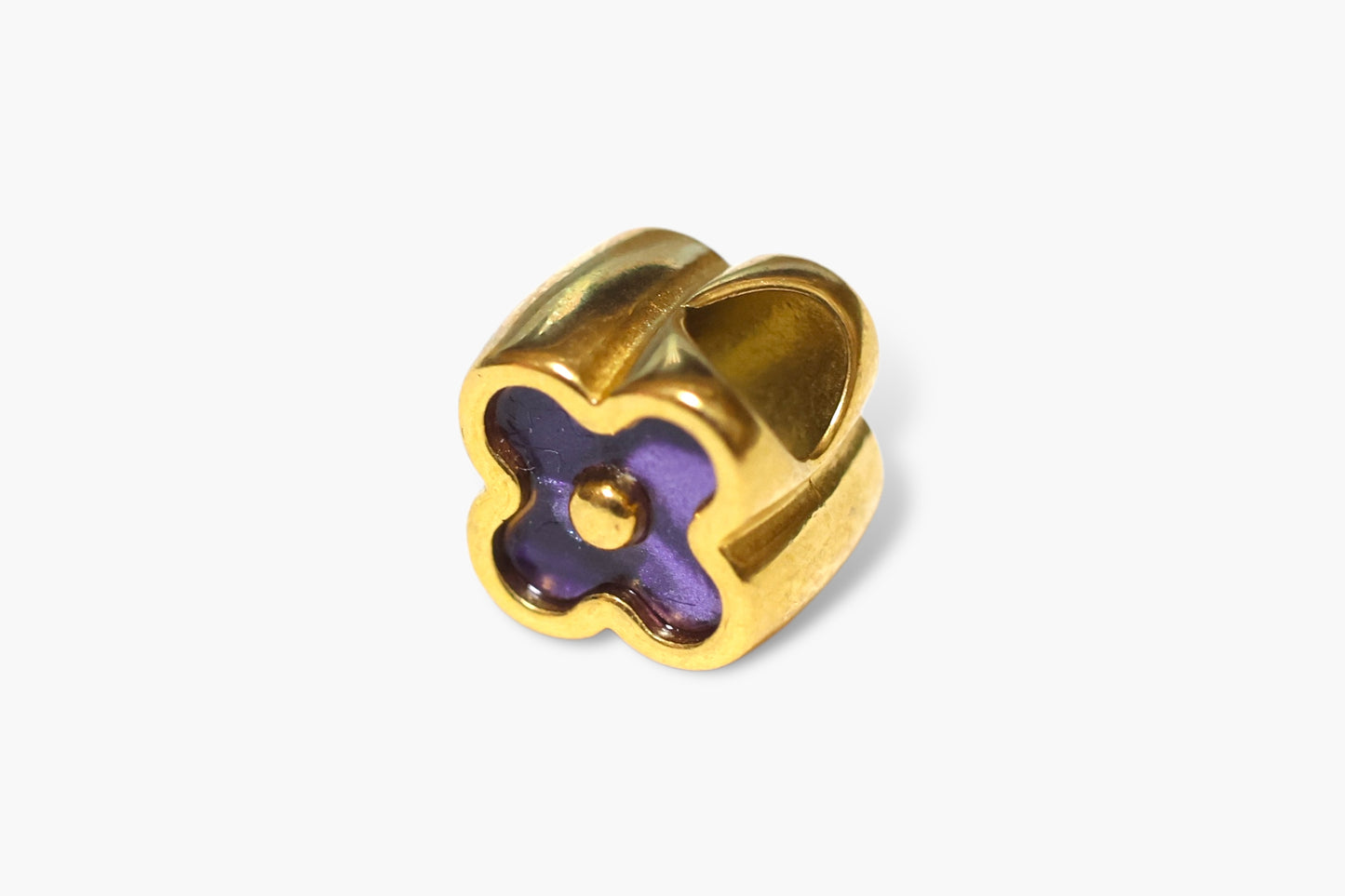 Gold charm with a purple center on a white background