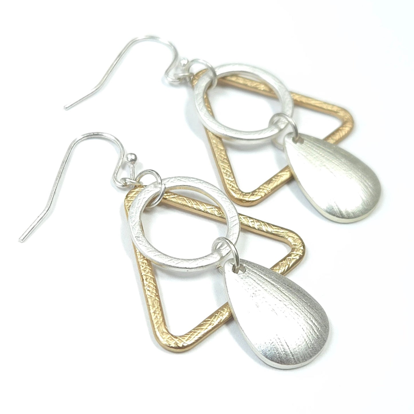 Pair of silver and gold earrings on a white background