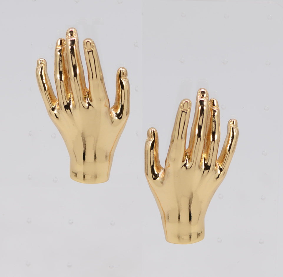 Gold hand-shaped earrings on a light gray background