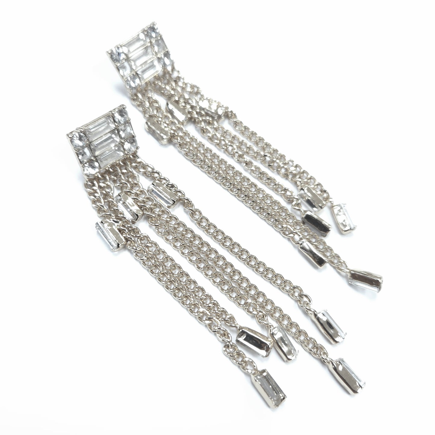 Pair of silver earrings with chain drops on a white background