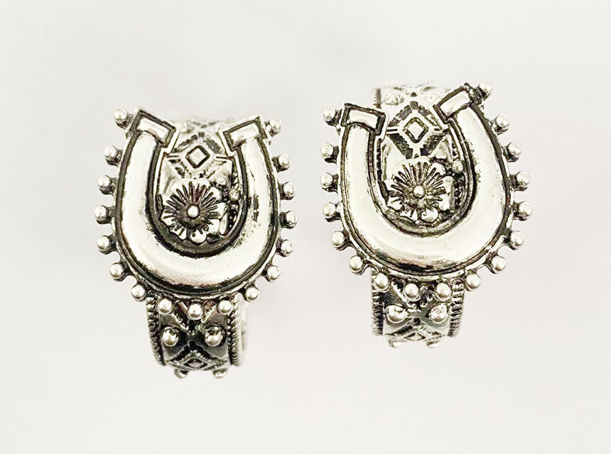 Pair of silver horseshoe-shaped earrings on a white background