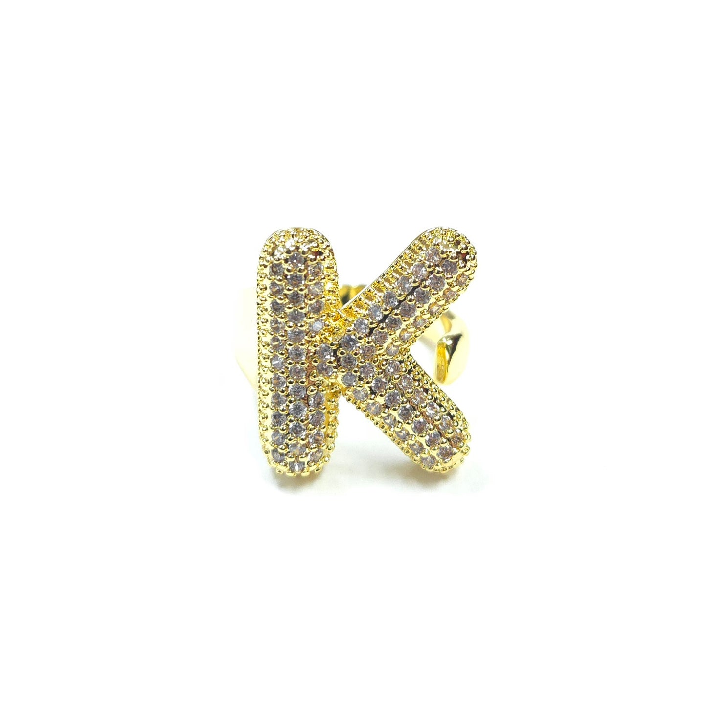 Gold letter 'K' ring with gemstones on a white background