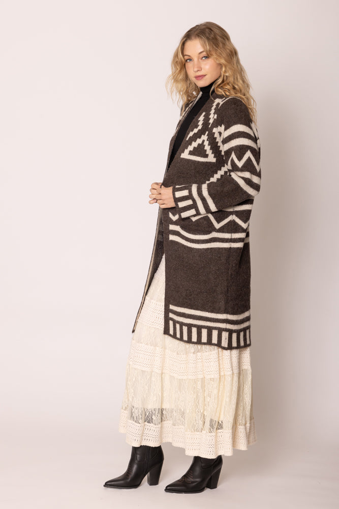 A girl wearing a brown poncho.
