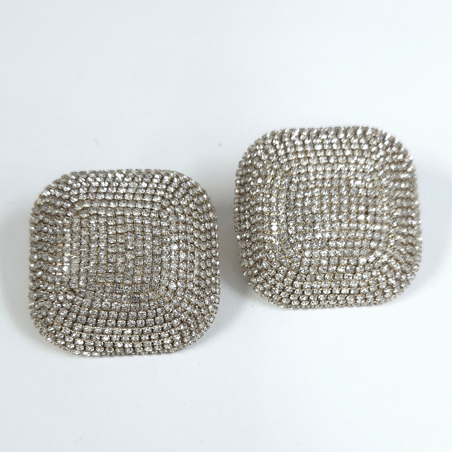Pair of square-shaped silver earrings on a white background