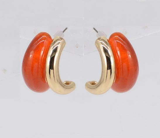 Gold hoop earrings with orange circular stones on a white background