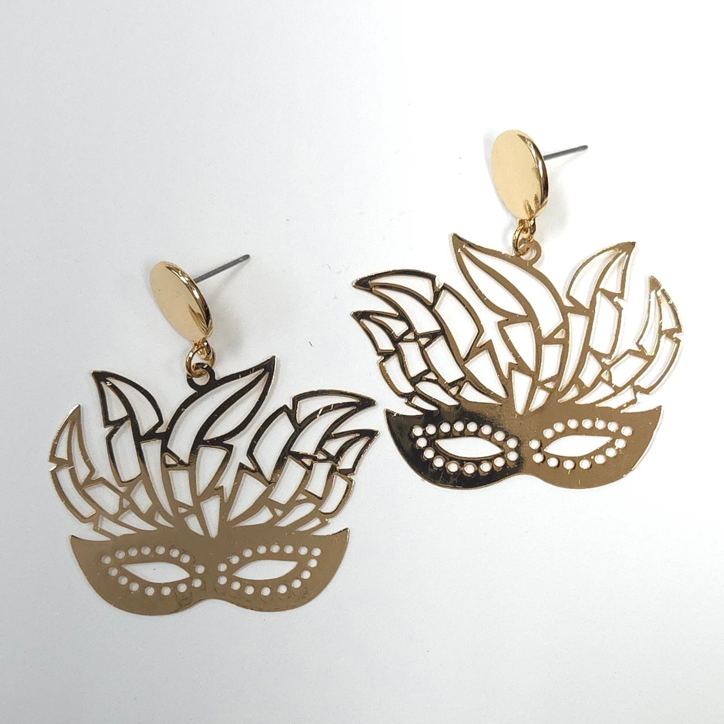 Pair of gold mask-shaped earrings on a white background