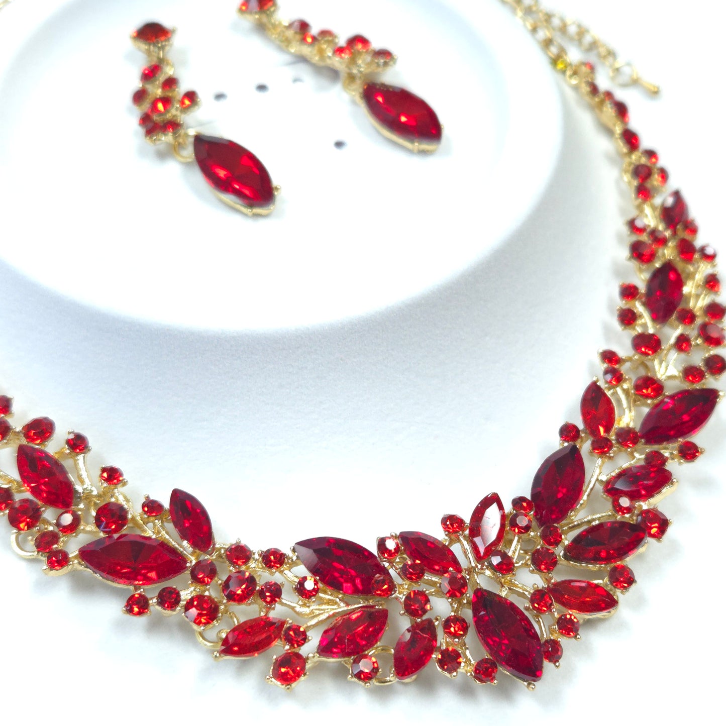 Jewelry set with red gemstones and gold accents on a white background