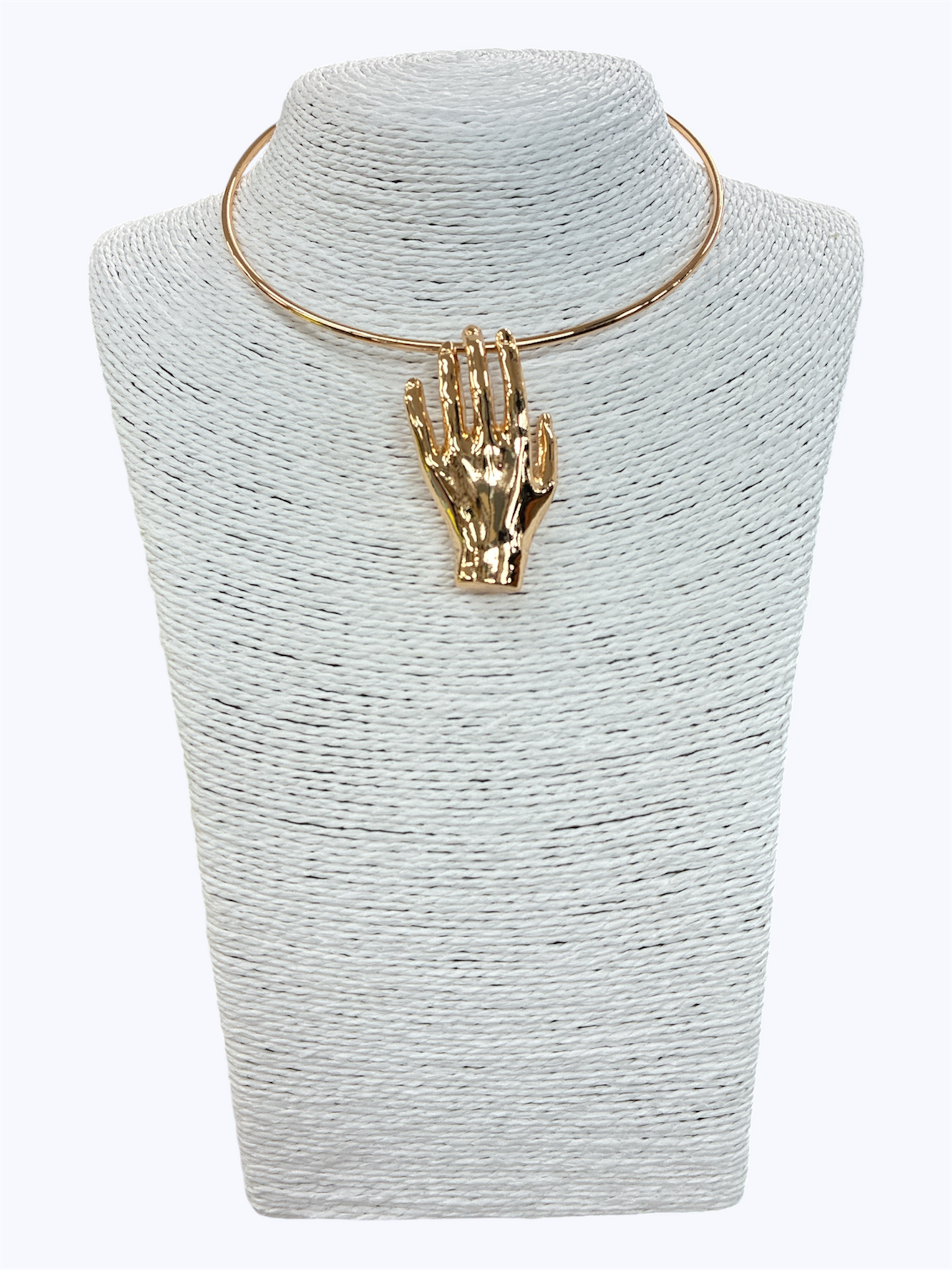 Gold-tone sculptural hand pendant choker necklace with minimalist open collar design displayed on textured jewelry bust for modern statement fashion accessories collection